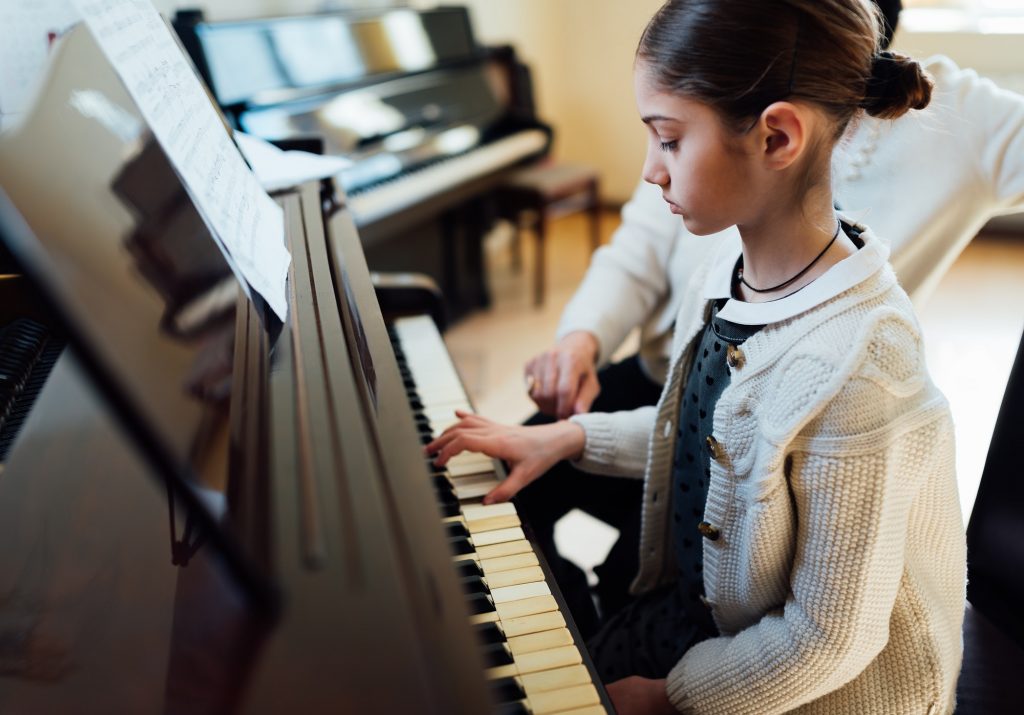 music teacher with the pupil at lesson piano